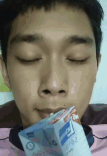 a young man with his eyes closed is drinking from a carton with the year 2007 on it