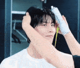 a man is getting his hair sprayed with a spray bottle .