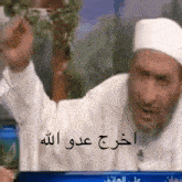 a man in a white hat with arabic writing on the bottom