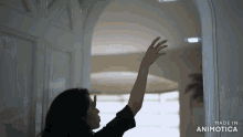 a woman opens a door with her hand and the words made in animatica on the bottom right