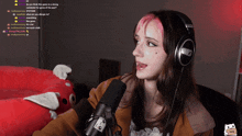 a woman wearing headphones is talking into a microphone with a cat on the bottom right