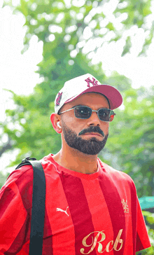 a man with a beard wears a red shirt that says rob