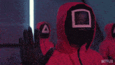 a person wearing a red hooded jacket with netflix written on the bottom right corner