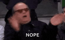 a man wearing sunglasses and a black jacket is making a funny face and saying nope .