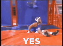 a man is laying on a trampoline with the word yes written above him