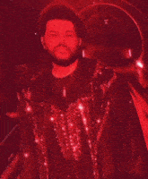 a man with a beard is wearing a red jacket with sequins on it .