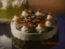 a cake with whipped cream and cherries on top of it .