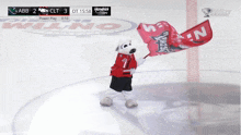 a mascot holding a red flag with the word n on it