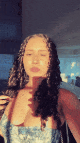 a woman with curly hair is taking a selfie with the sun shining on her face