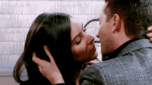 a man and a woman are kissing and the man is touching the woman 's hair