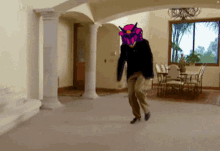 a man with a robot head is walking in a room