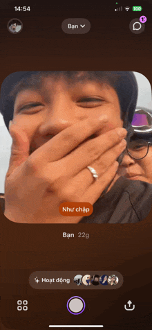 a phone screen shows a picture of a man covering his mouth and the time is 14:54
