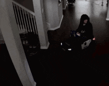 a person sits in a chair in a dark hallway