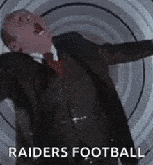 a man in a suit and tie is screaming while standing in front of a spiral .