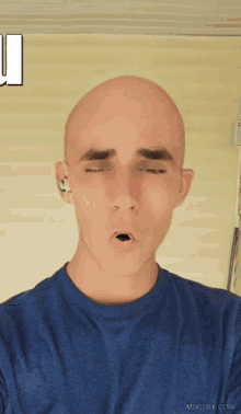 a man in a blue shirt has his eyes closed and a muglife.com logo in the corner
