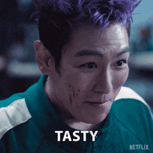 a man with purple hair has the word tasty in front of his face