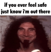 a man with long curly hair and a beard is smiling while holding a baby .