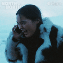 a woman wearing a fur coat is talking on a cell phone with the words north of north written above her