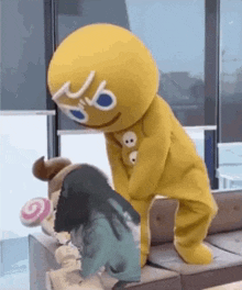a gingerbread man mascot is standing next to a woman .