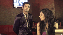 a man in a purple suit and tie stands next to a woman in a purple dress