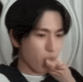 a close up of a man eating something with his hand .