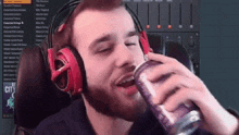 a man wearing headphones is drinking from a bottle