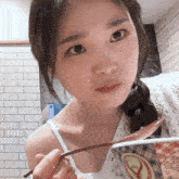 a woman is holding a spoon in front of a bowl of food