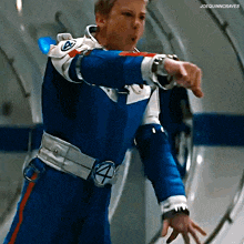 a man in a blue and white superhero suit is pointing at something
