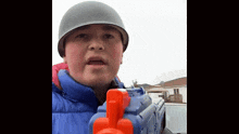 a young boy wearing a helmet holds a toy gun