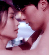 a man and a woman are kissing each other in a close up of their faces .