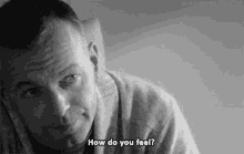 a black and white photo of a man laying down and asking how do you feel .