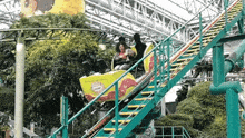 a man and a woman are riding a roller coaster at an amusement park .
