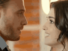 a man and a woman are looking at each other .