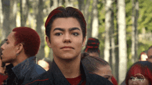 a young man with red hair is standing in front of a crowd of people with disney + written on the bottom