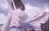 a girl with fairy wings on her back is standing in front of a cloudy sky