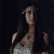 a woman wearing a necklace and a headband is smiling .