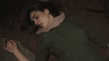 a woman with a scarf around her neck is laying on a bed
