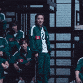 a man in a green tracksuit with the number 8 on it
