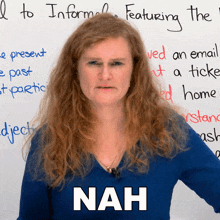 a woman stands in front of a white board with the word nah written on it