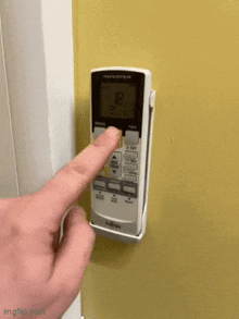 a person is pressing a button on a remote control that says inverter