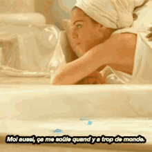 a woman in a bathtub with a towel wrapped around her head says moi aussi