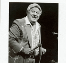 a man in a suit is singing into a microphone