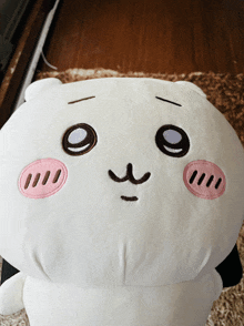 a stuffed animal with a sad face is laying on a rug