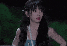 a woman with a lanyard around her neck is making a funny face with her hand