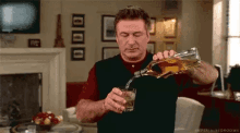 a man is pouring whiskey into a glass .