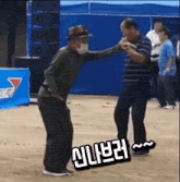 a man wearing a mask is dancing with another man on a dirt field .