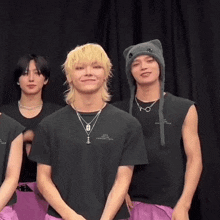 a group of young men are standing next to each other in front of a black background .