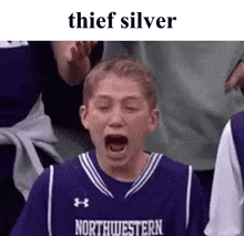 a boy in a purple northwestern jersey is screaming