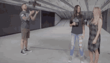 a man is holding a gun and a woman is holding a cup of coffee in a shooting range .