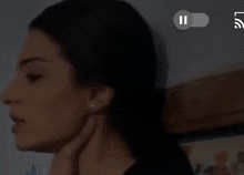 a close up of a woman 's face with a pause button above her